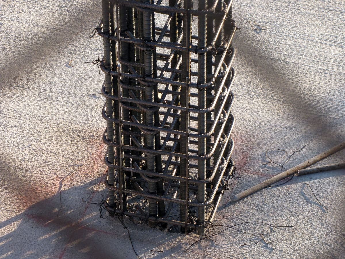 Close-up of a tied steel reinforcement cage standing on a concrete slab